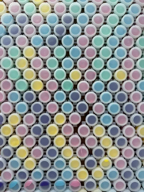 Rows of little sealed paint pots in pastel pink, yellow, blue and purple